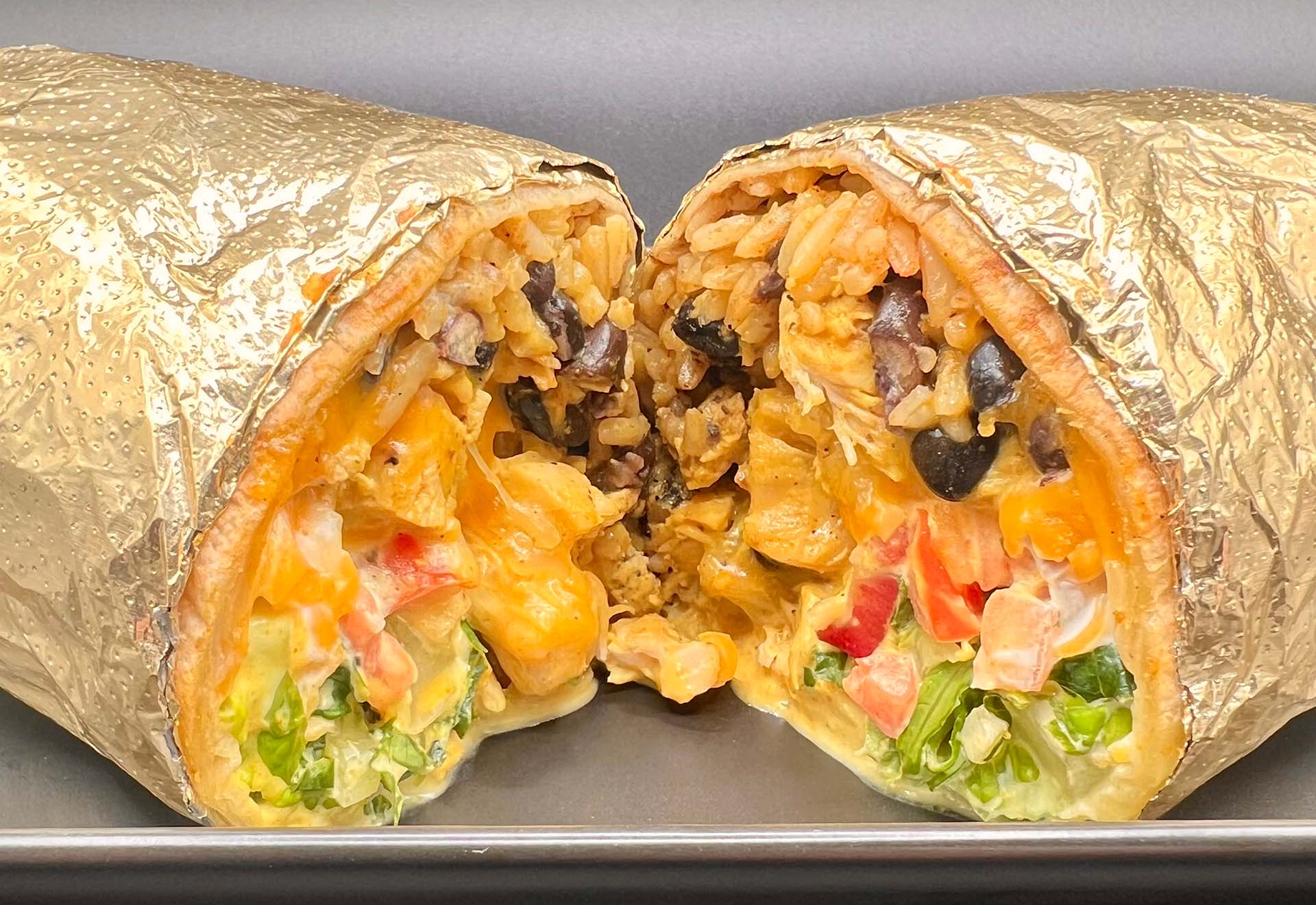 An oozy, overstuffed burrito wrapped in gold foil.
