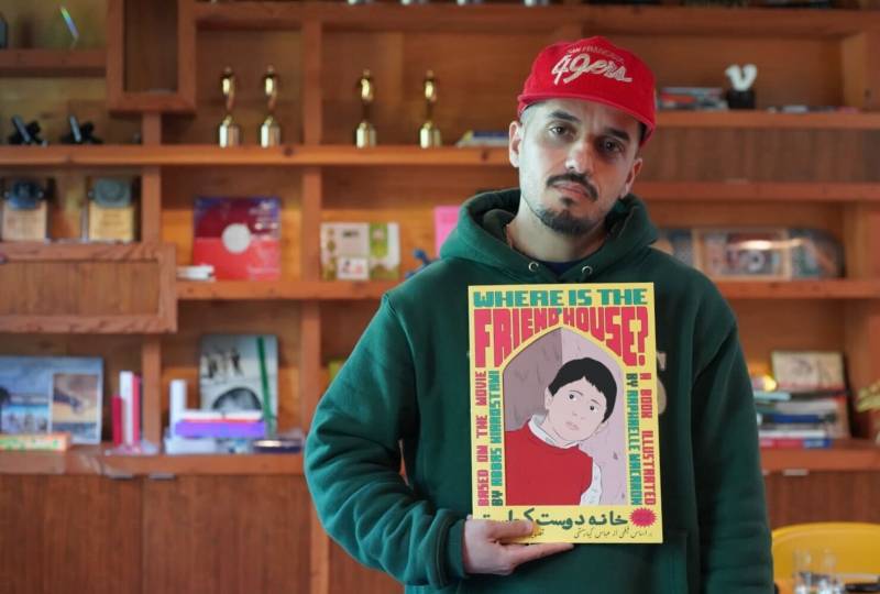 Mohammad Gorjestani holding a copy of his "Where Is The Friend's House?" book.