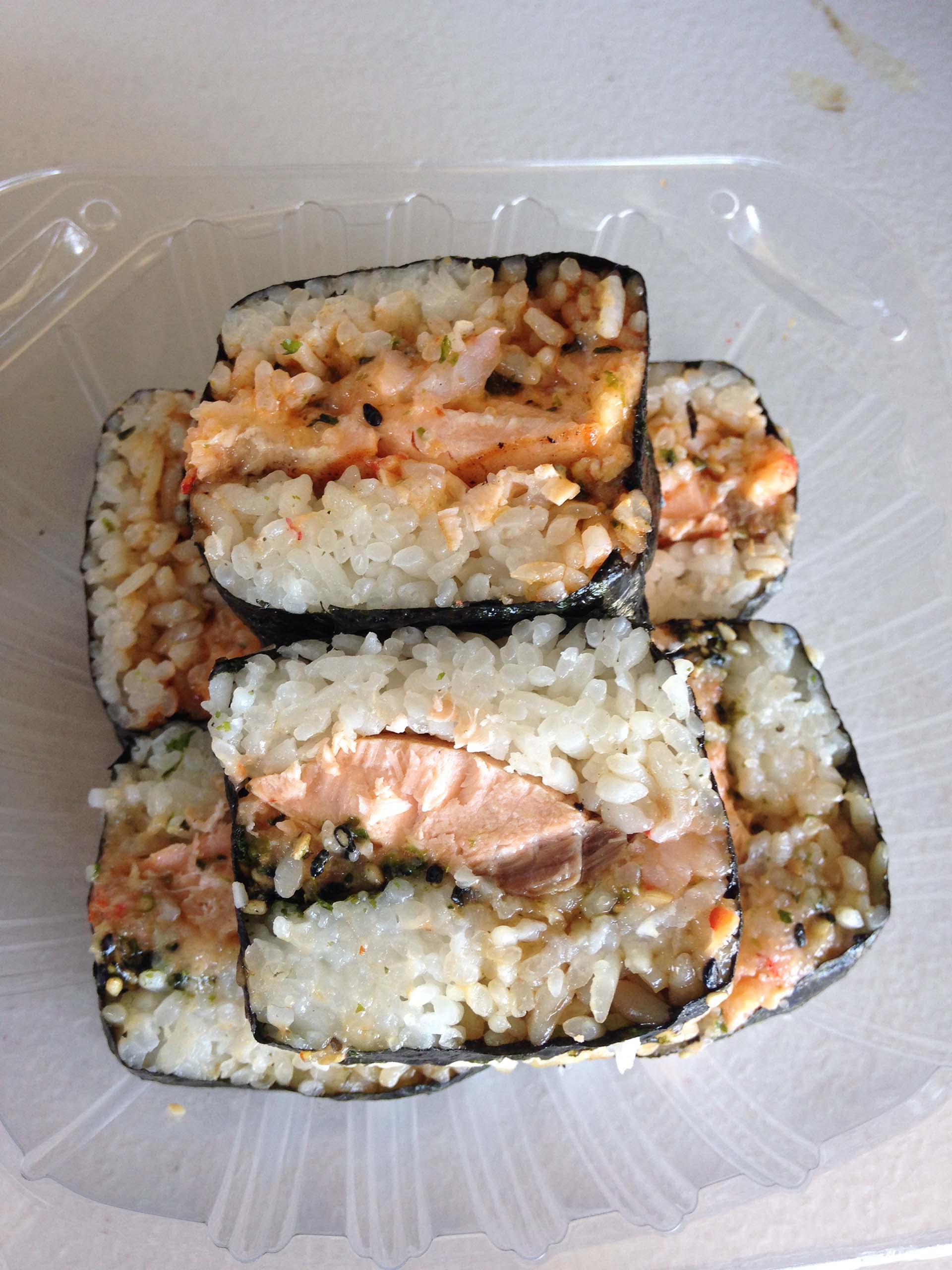 A stack of girthy musubi stuffed with rice, salmon and crawfish.