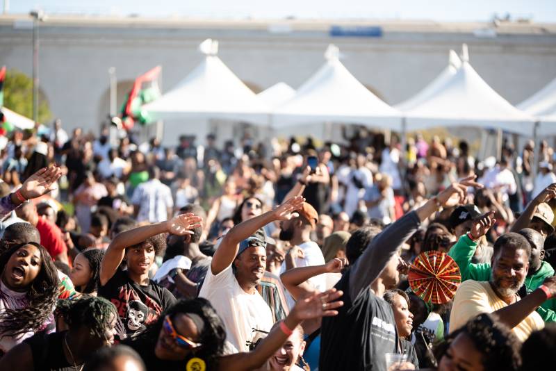 attendees dance together at an outdoor Black music and culture festival