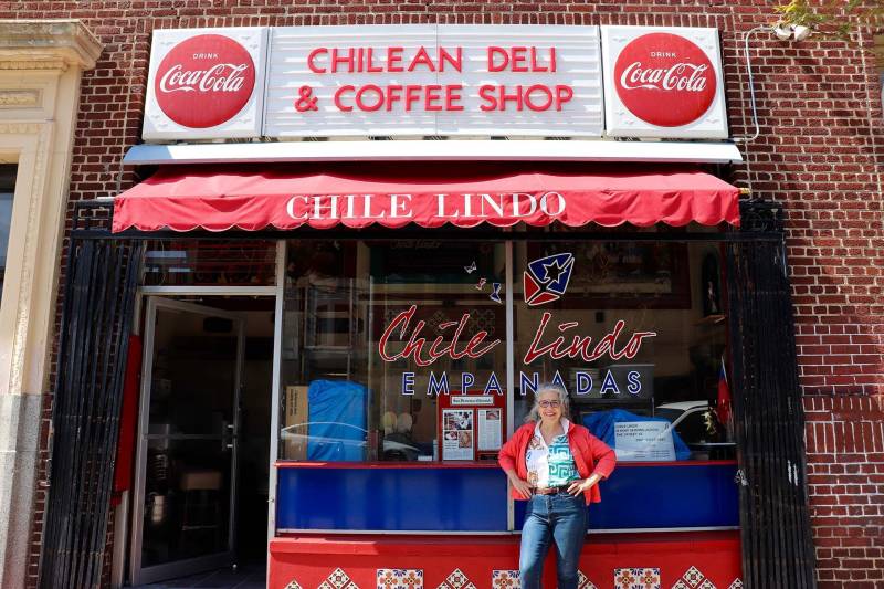 A Chilean food maker stands in front of her colorful shop on 16th Street in San Francisco