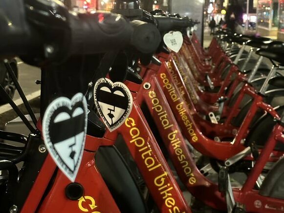 A row of city bikes with protest art on them