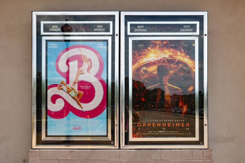 movie posters for 'barbie' and 'oppenheimer' next to each other