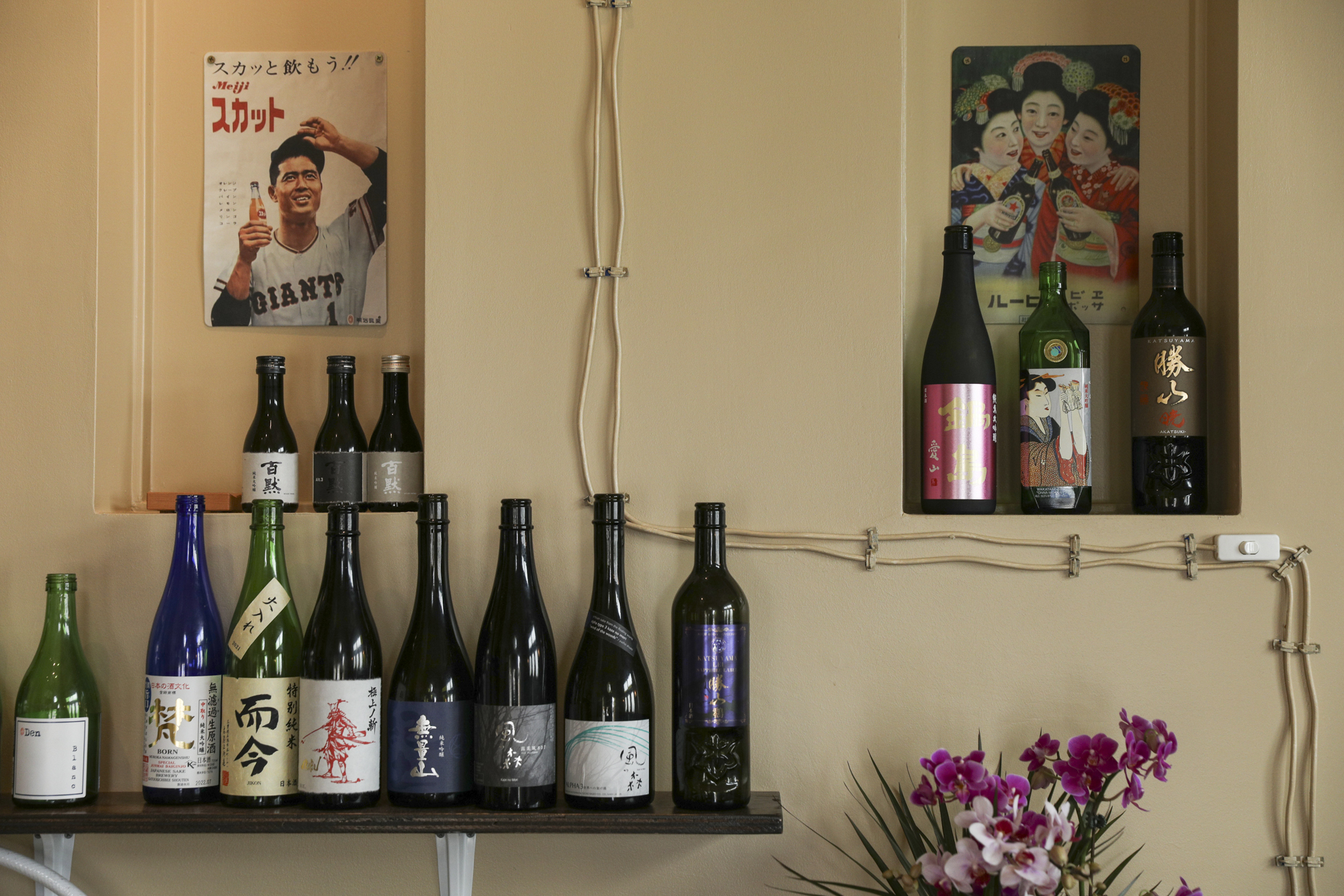 Bottles and posters sit on shelves along a wall.