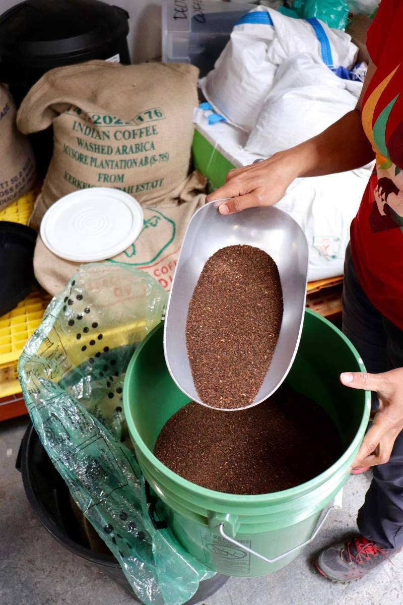 a woman scoops up chicory mix that she blends with her Indian coffee