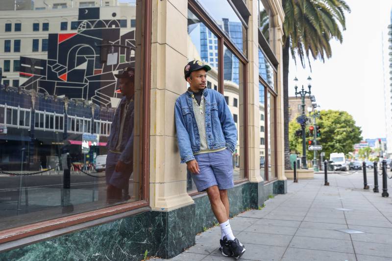 A young Oakland rapper leans against the glass window outside of the Fox Theater