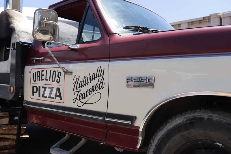 a vintage Ford pick up with a Urelio's Pizza logo on the passenger door