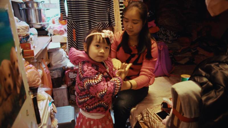 a young Chinese American girl in pink clothes and her mother, a Chinese woman, in a crowded room