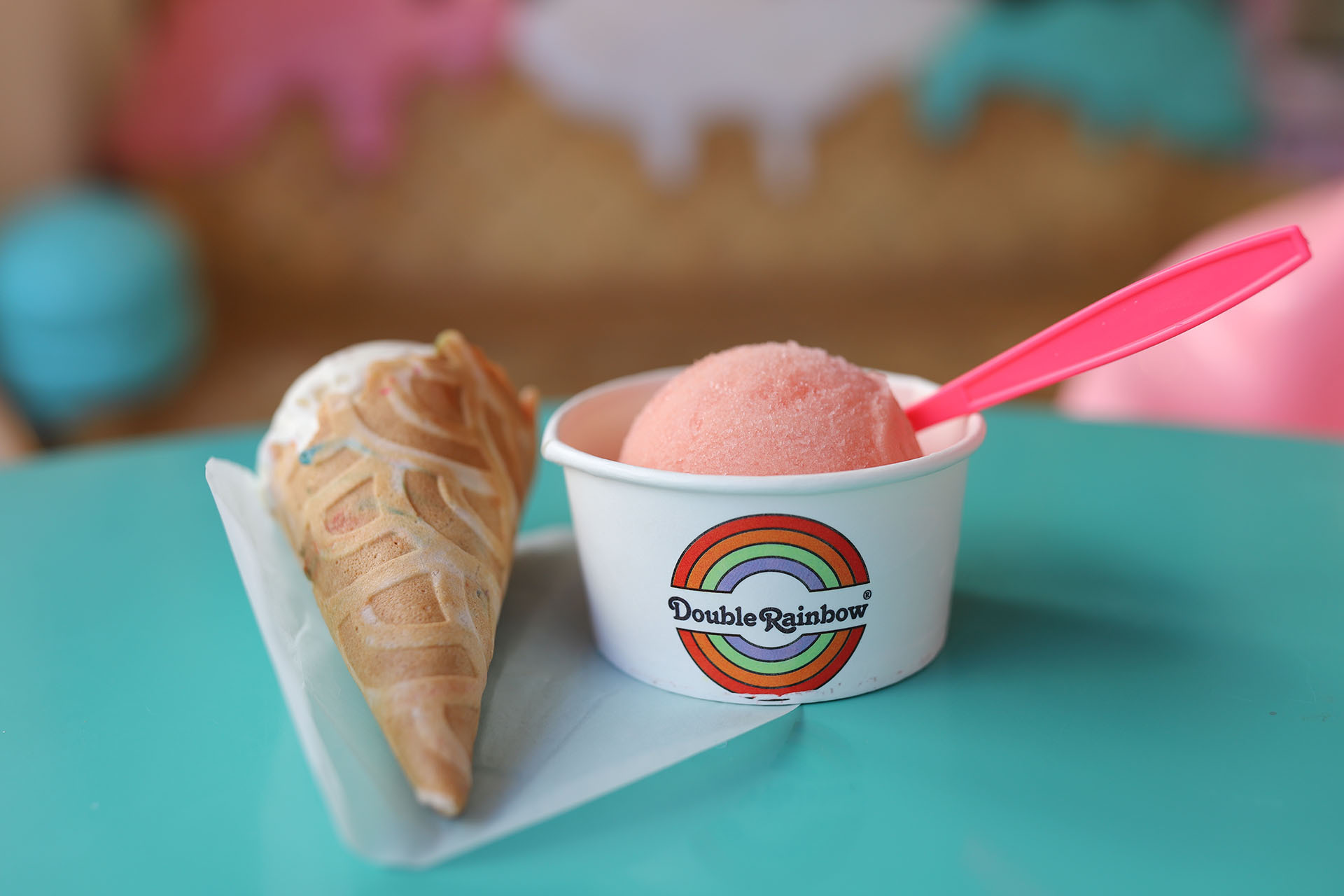a scoop of guava Italian ice and an ice cream cone inside an ice cream parlor