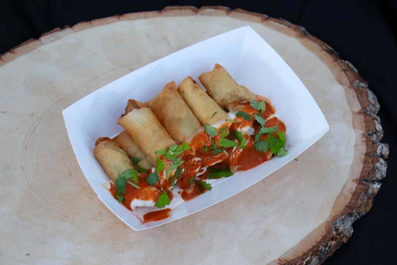 a plate of lumpia with orange sauce on display
