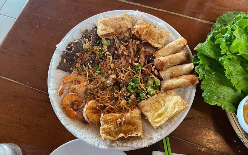 An abundant platter of fillings for make-your-own Vietnamese spring rolls, with shrimp, beef, fried egg rolls and more.