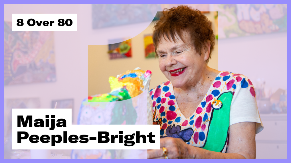 An older woman in a hand-painted shirt looks down at a colorful sculpture, the text "8 Over 80" and "Maija Peeples-Bright" is overlaid
