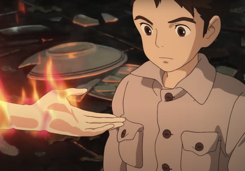 Animation in the Japanese manga style depicts an adolescent boy staring at an outreached hand in front of him. The hand is on fire.