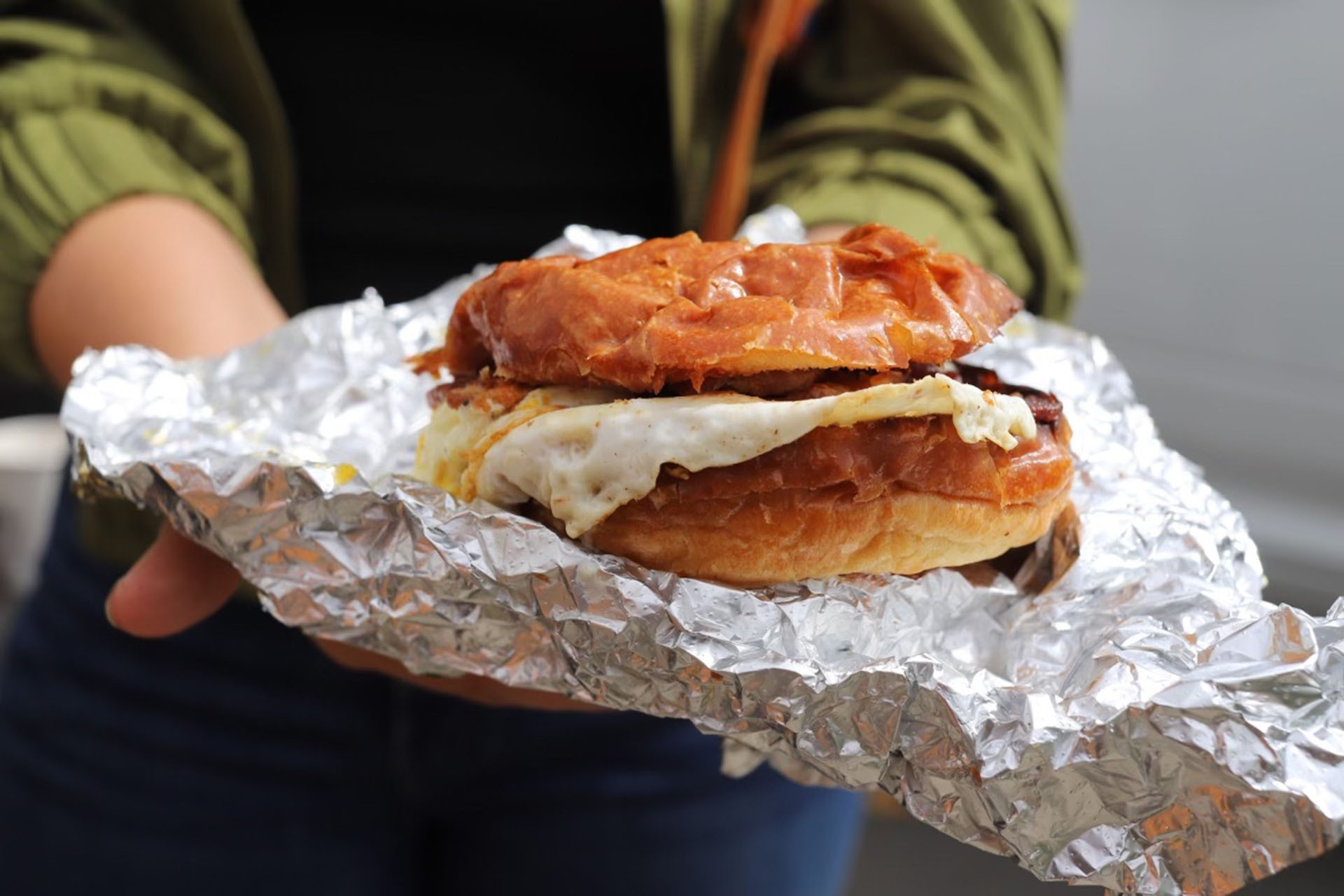 sideview of an egg breakfast sandwich wrapped in tin foil