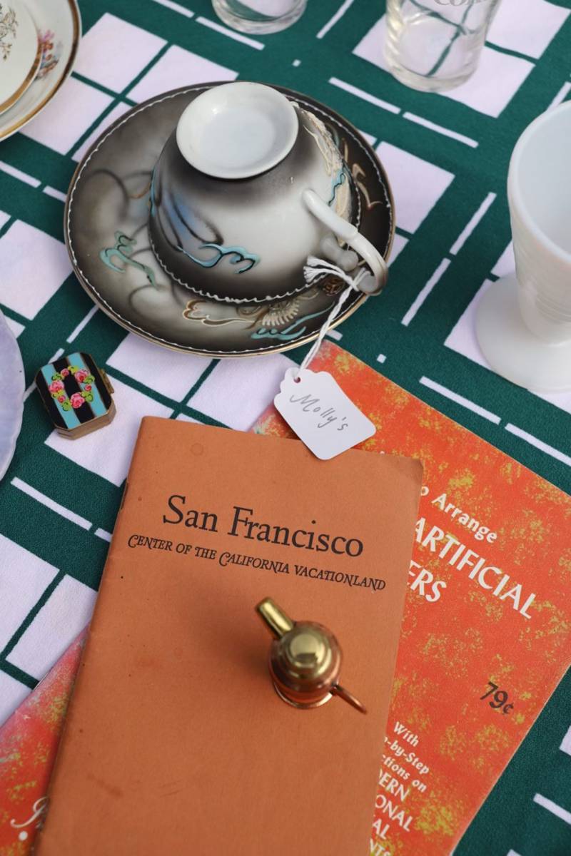a San Francisco tourism book is laid out on a patterned table outside next to a