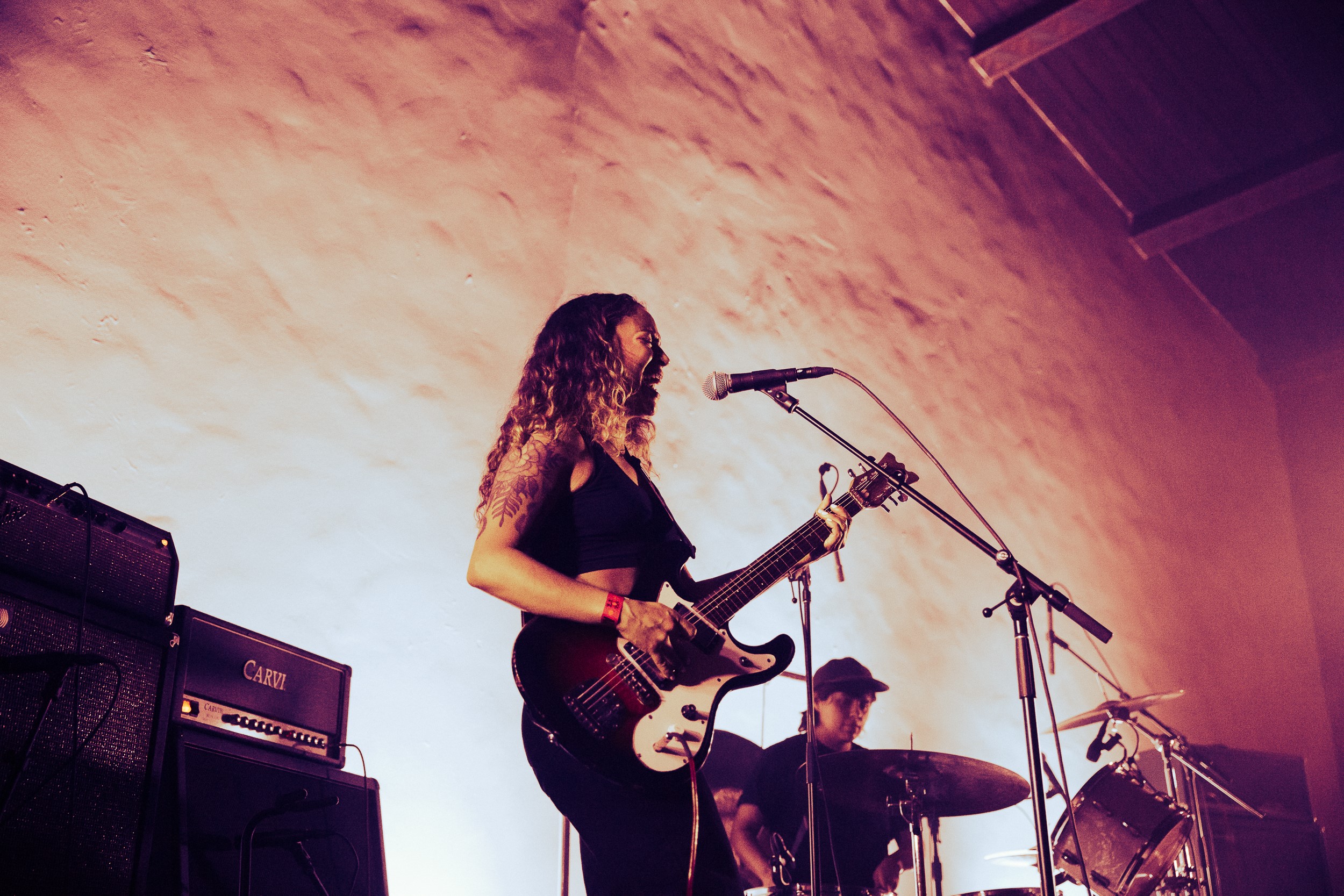 Maria strums her guitar and Coley plays drums at Ragana's live performance at Hollywood Forever in Los Angeles.