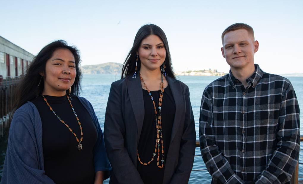 Cultural District Staff, Paloma Flores, Sharaya Souza, and Tal Quetone pose for portraits at Fort Mason in San Francisco. Alcatraz floats in the background, a significant landmark.