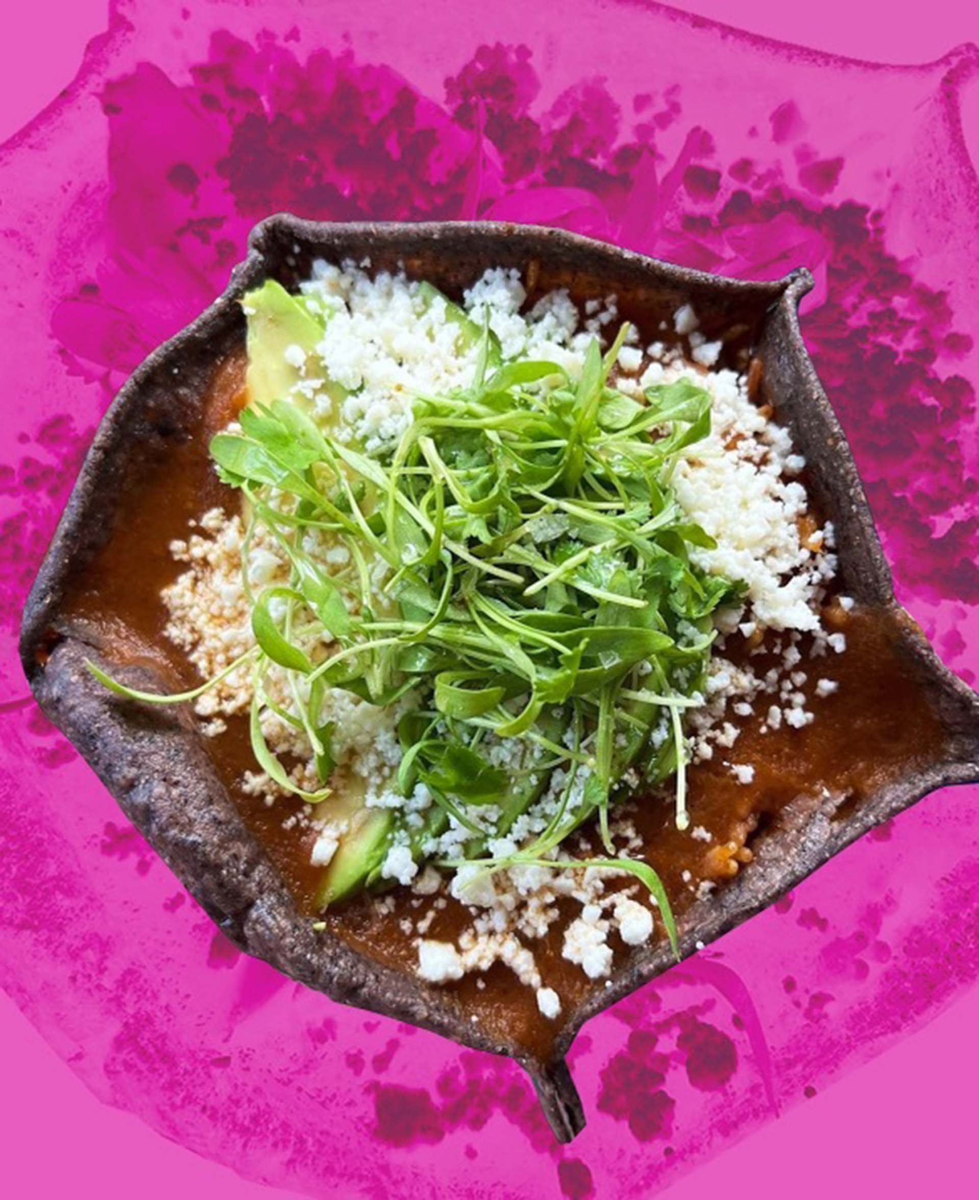 filled with Mexican soup presented against a bright pink backdrop