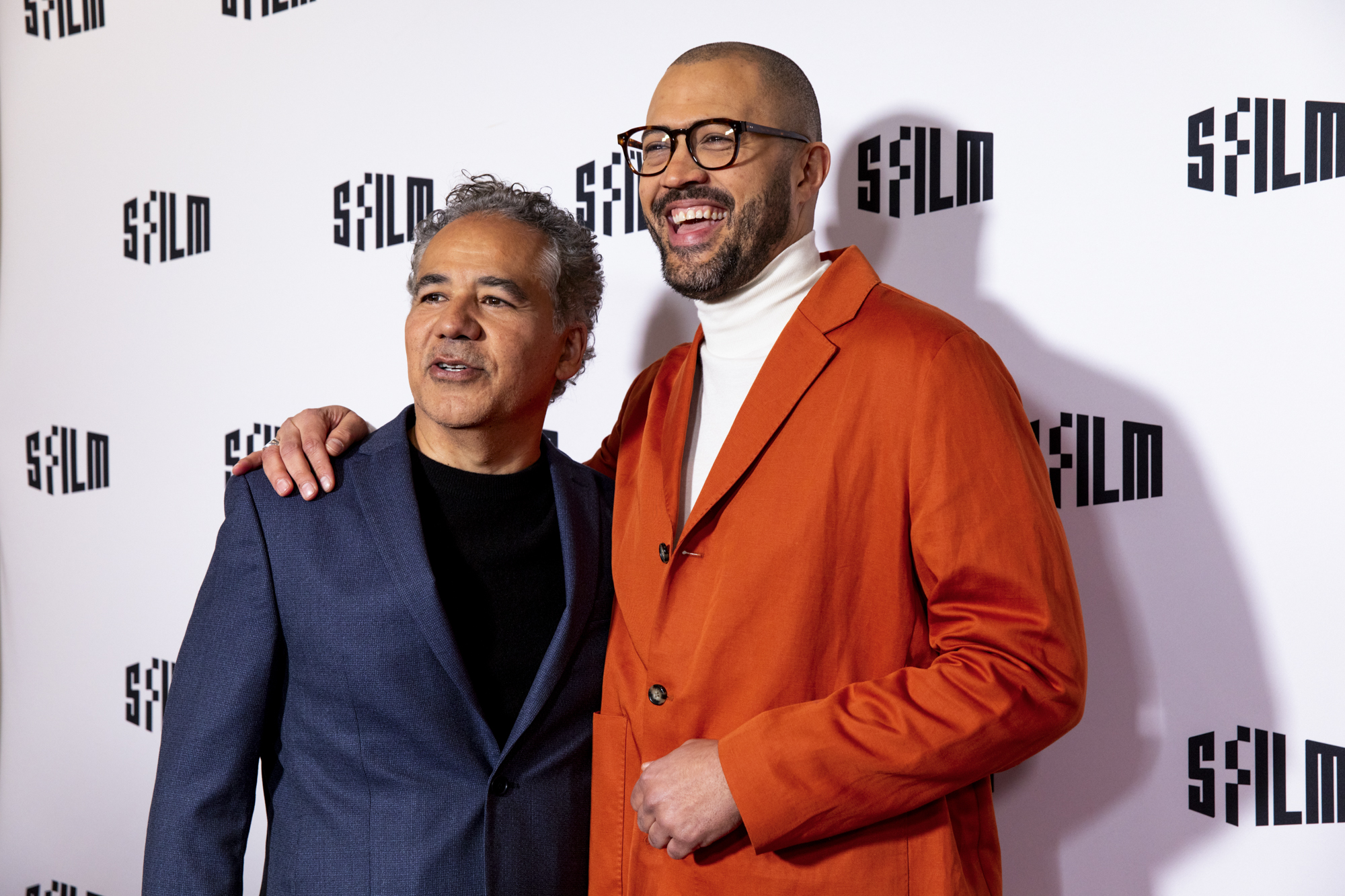 Two people wearing sport coats in front of a backdrop with the words "SFFILM" written on it.