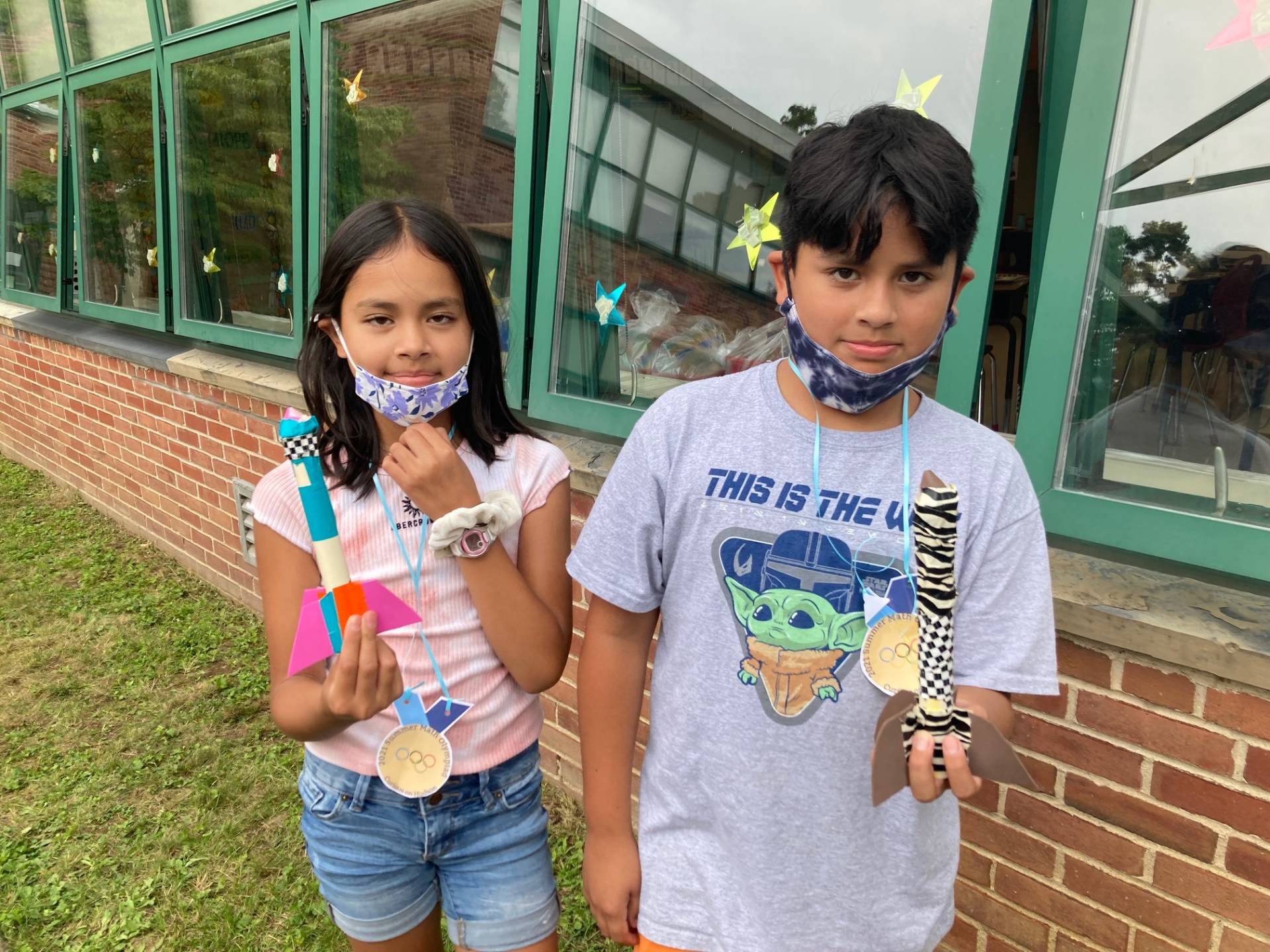 Two students display their rockets prior to launch.