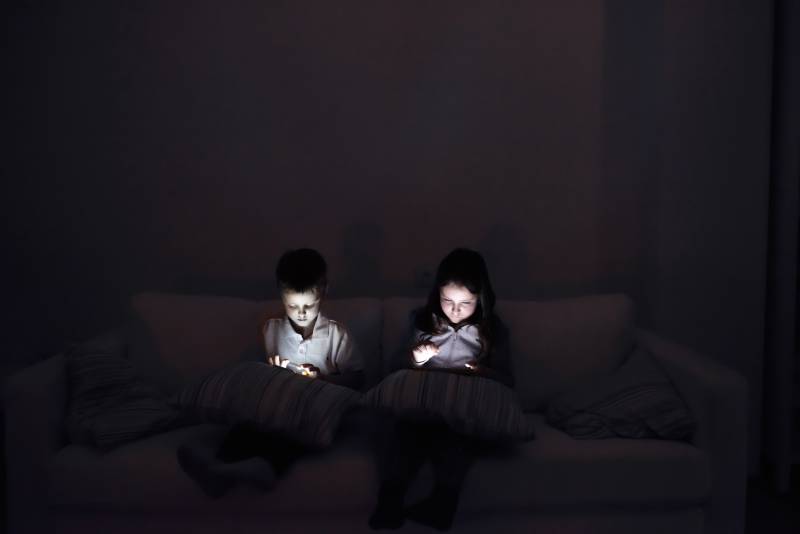 Two children having screen time in the dark