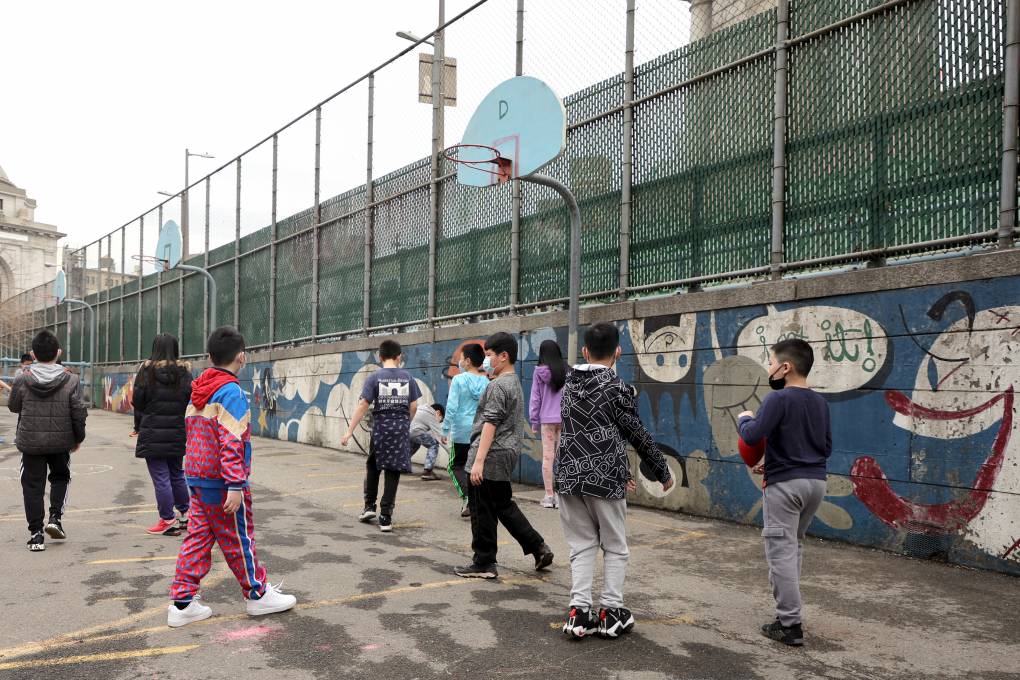 Students play at recess on an outdoor court.