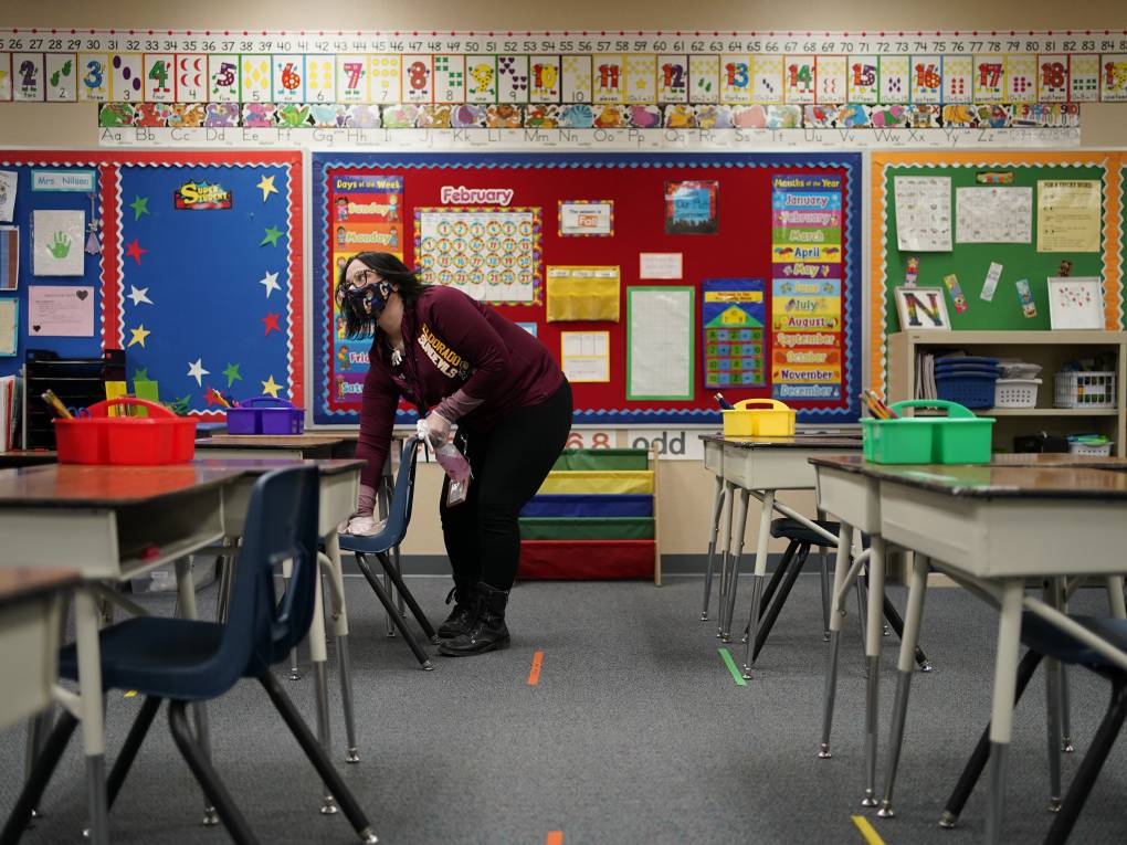 A teacher cleans a desk in a classroom during a media tour at Dorothy Eisenberg Elementary School in Las Vegas.  (John Locher/AP)