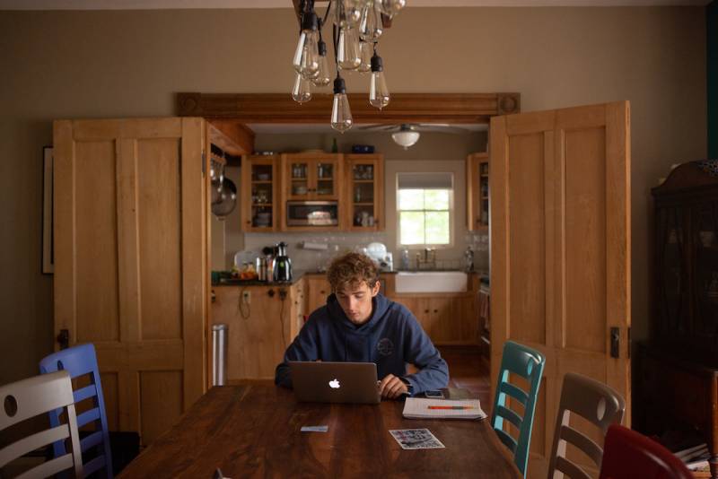 Male student learning in dining room