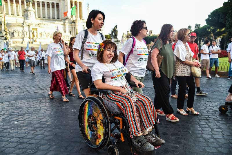 Woman in a wheelchair taking part in a disability pride parade