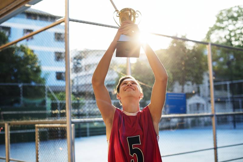 Teenage boy holding up trophy