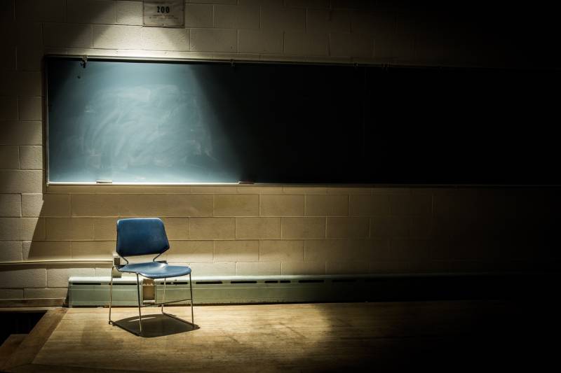 An Empty Chair in a Dark Classroom