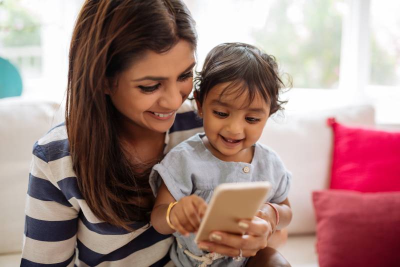Indian mother and child playing game on a smartphone