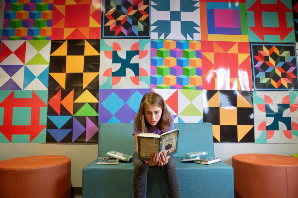 A seventh-grade students reads a book in Sutton Middle School’s library.