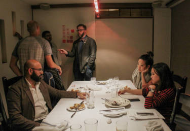 Make America Dinner Again guest Affan Khokhar (left, seated) talks with hosts Tria Chang and Justine Lee (front right, seated) after the dinner as guests (from left to right) Afam Agbodike, Walter Rodriguez and Nick Tucker continue their conversation.