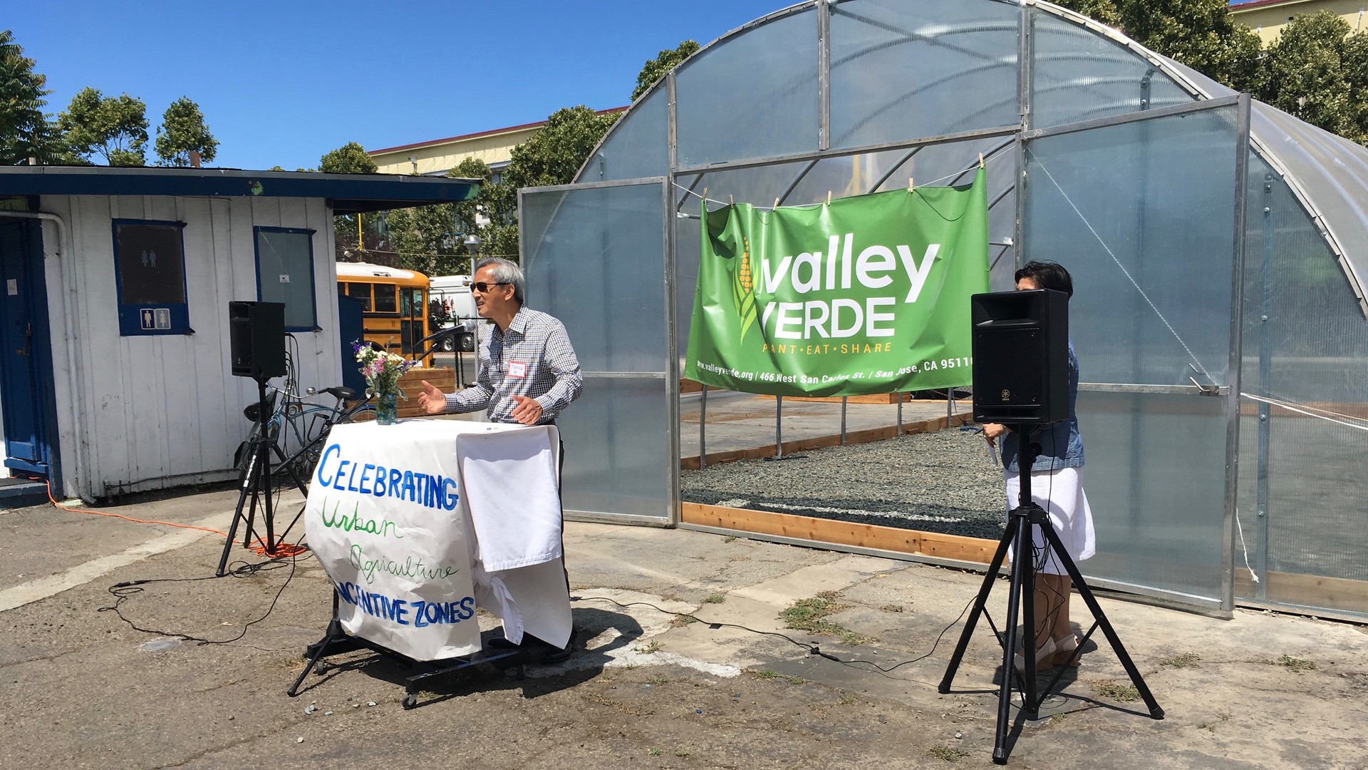 Thang Do addresses a crowd that gathered for the grand opening of the greenhouse on his property. He plans to develop after five years but is happy to let Valley Verde have the run of the place before then. Do says "At a time when national politics is so divisive, nice to see local community come together."