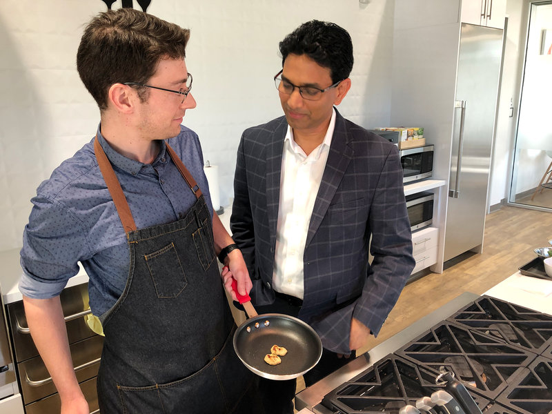 Memphis Meats CEO Uma Valeti (right) stands with Morgan Rease, the company's formulations scientist, while they cook up a sample of cell-based chicken.