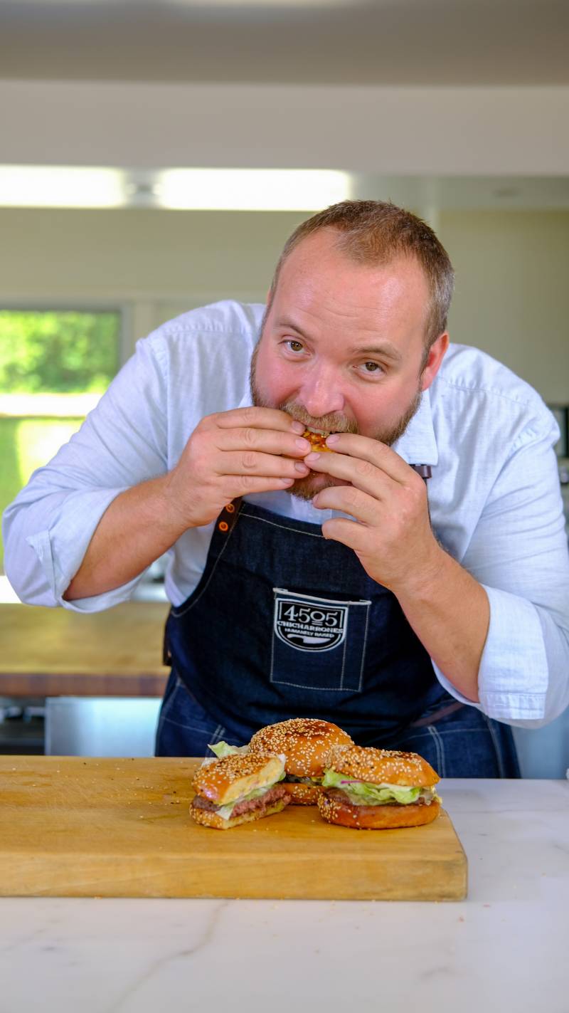 Chef Ryan Farr digs into his Best Damn Cheeseburger with Shhh! Sauce. 