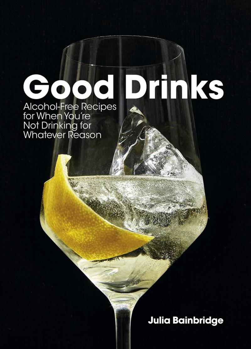 Stemmed glass wtih an ice cube, clear liquid and a lemon peel on a black background. Book cover for Good Drinks