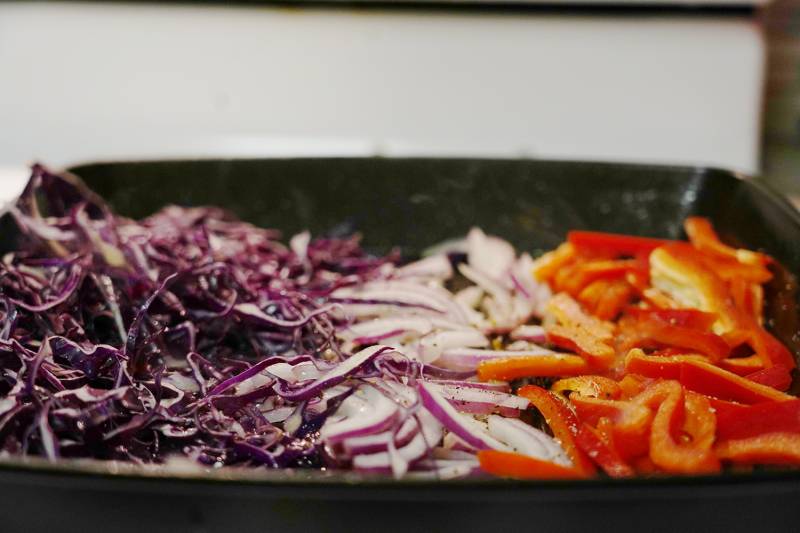 Cabbage, purple onions and bell peppers on a grill pan