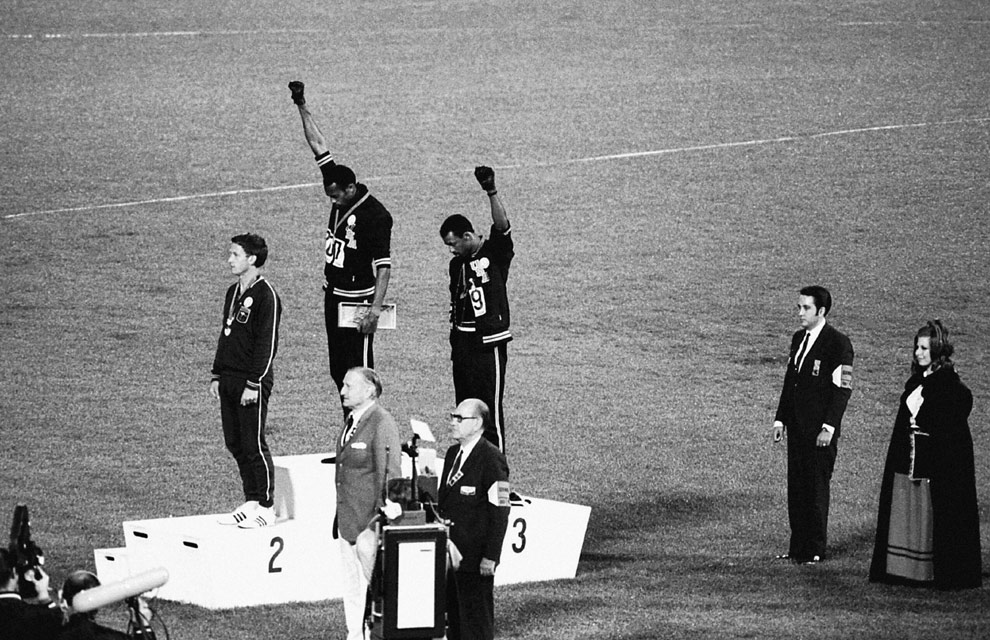 During the medals ceremony at the 1968 Summer Olympics in Mexico City, U.S. track stars Tommie Smith (center) and John Carlos (right) unexpectedly give the Black Power salute. Associated Press