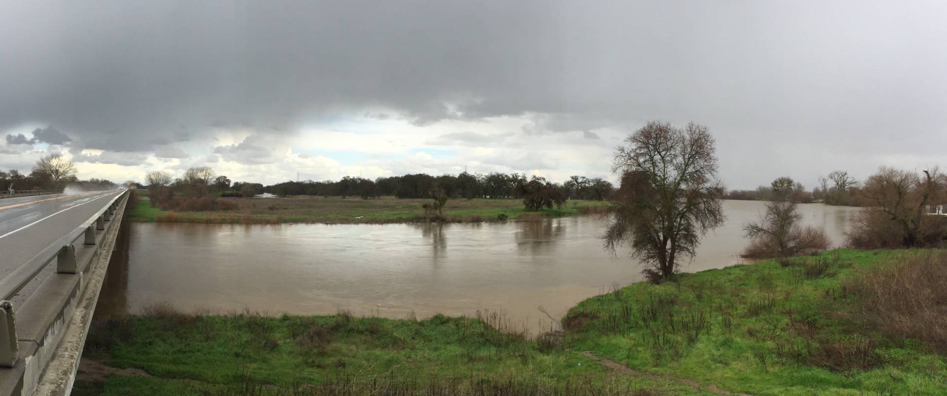 The San Joaquin River, which often runs dry before reaching its mouth, spreads out along Hwy 132 west of Modesto, after weekend storms. Craig Miller/KQED