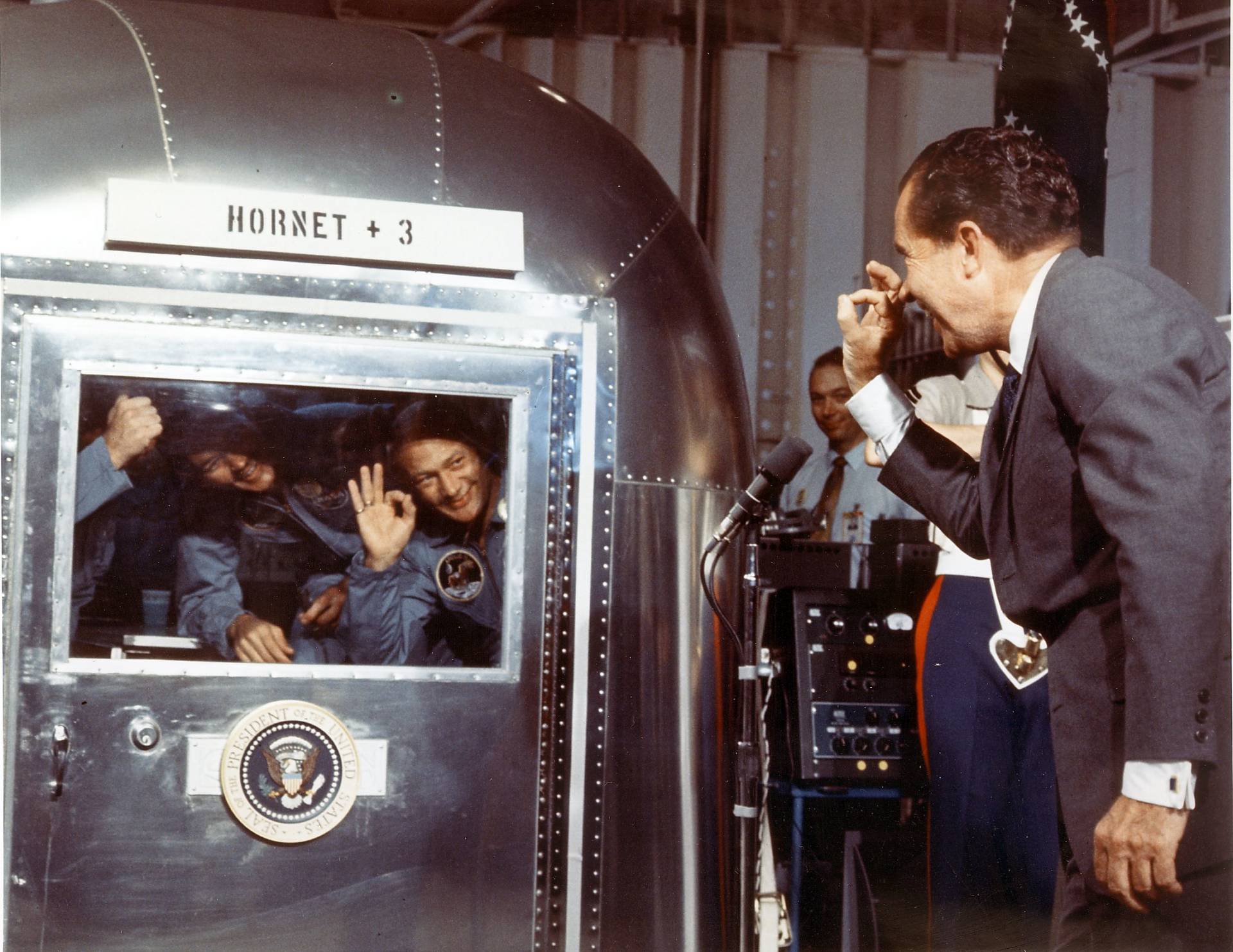 President Richard M. Nixon and the Apollo 11 astronauts exchange "A-OK signs" through the window of the Mobile Quarantine Facility 24 July 1969 aboard the USS Hornet.  NASA/AFP/Getty Images