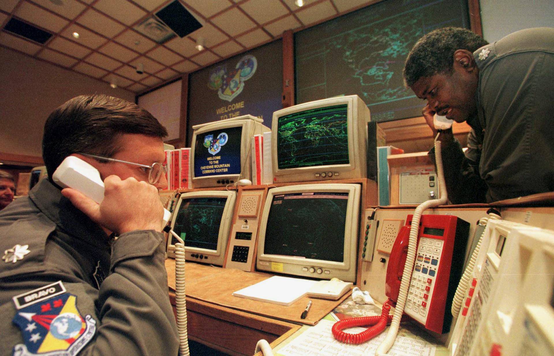 Missile Commanders confirm a launch warning over the phone during a practice drill at the North America Aerospace Defense Command, Nov. 9, 1999.  At the time, there were worries over whether the Y2K bug would render the complex missile tracking system inoperational after computers switched to the new year.  MARK LEFFINGWELL/AFP via Getty Images