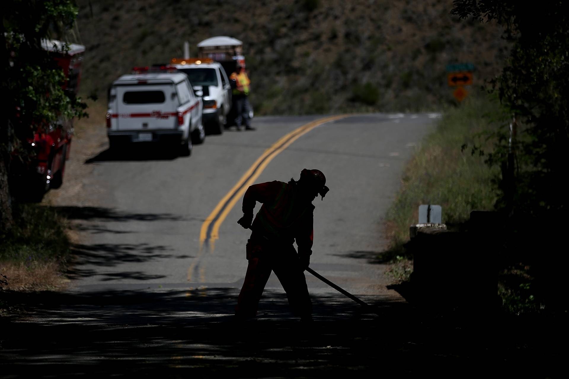 A fire crew sweeps the road to remove ground fuels and small trees along a road to help reduce the spread of fire in the event of a wildfire. Justin Sullivan/Getty Images