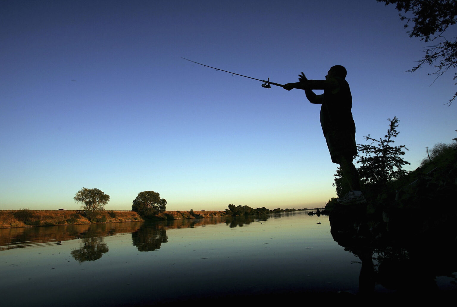  A fisherman casts his line into the Sacramento River in the Sacramento-San Joaquin River Delta on September 29, 2005 south of Sacramento, California.