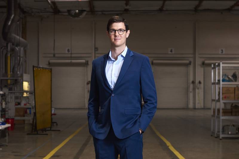 Man in blue business suit stands in warehouse