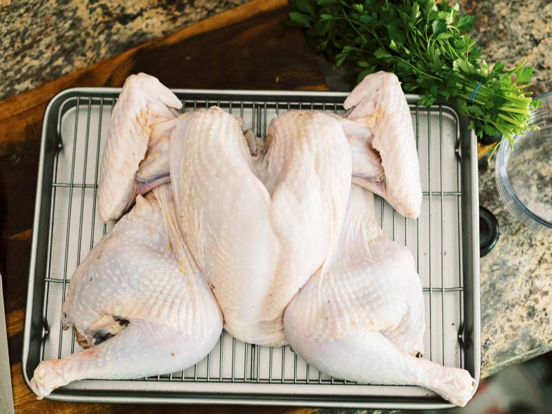 To spatchcock your turkey, you need to remove the backbone and flatten the bird.