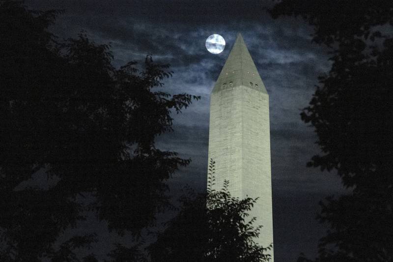 The moon is obscured by clouds as it passes behind the Washington Monument on August 11, 2022 in Washington, DC. The so-called Sturgeon Moon is the fourth and final super moon of 2022. 