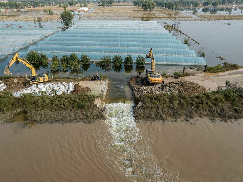 An aerial photo shows rescuers digging a spillway with an excavator to release flood waters after heavy rainfall at a flooded area in Jiexiu in the city of Jinzhong in China's northern Shanxi province.