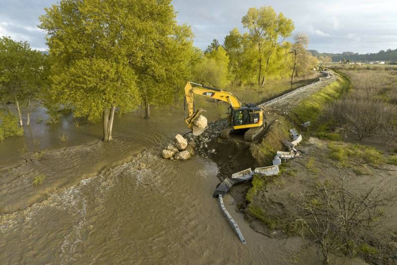 A drone provides a view of an excavator placing large rocks to close a levee break caused by flood waters from the Pajaro River near the township of Pajaro in Monterey County, California. 